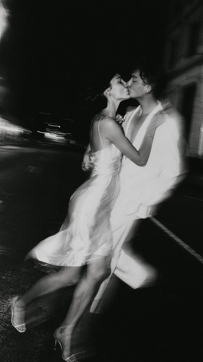 Una joven pareja de la generación Z comparte un beso borroso vestida con traje de novia minimalista en una calle de Nueva York