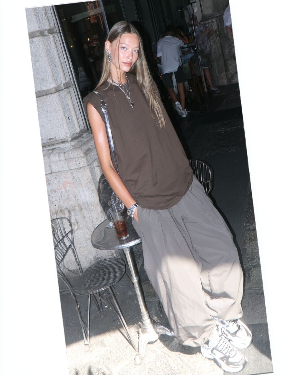 A female model wears a relaxed sleeveless streetwear vest with oversized trousers