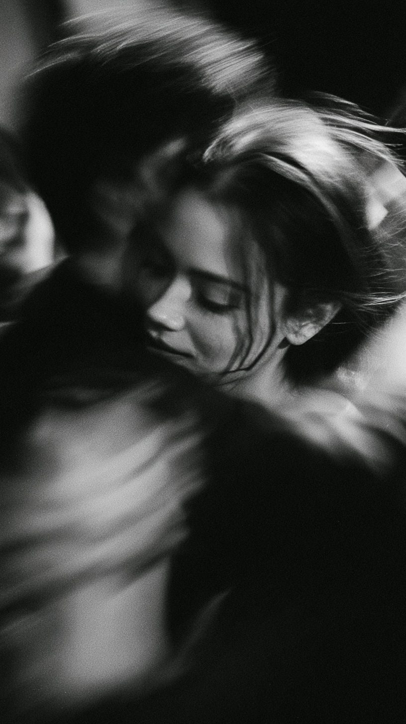 Una foto borrosa en blanco y negro de dos personas abrazándose en una habitación oscura