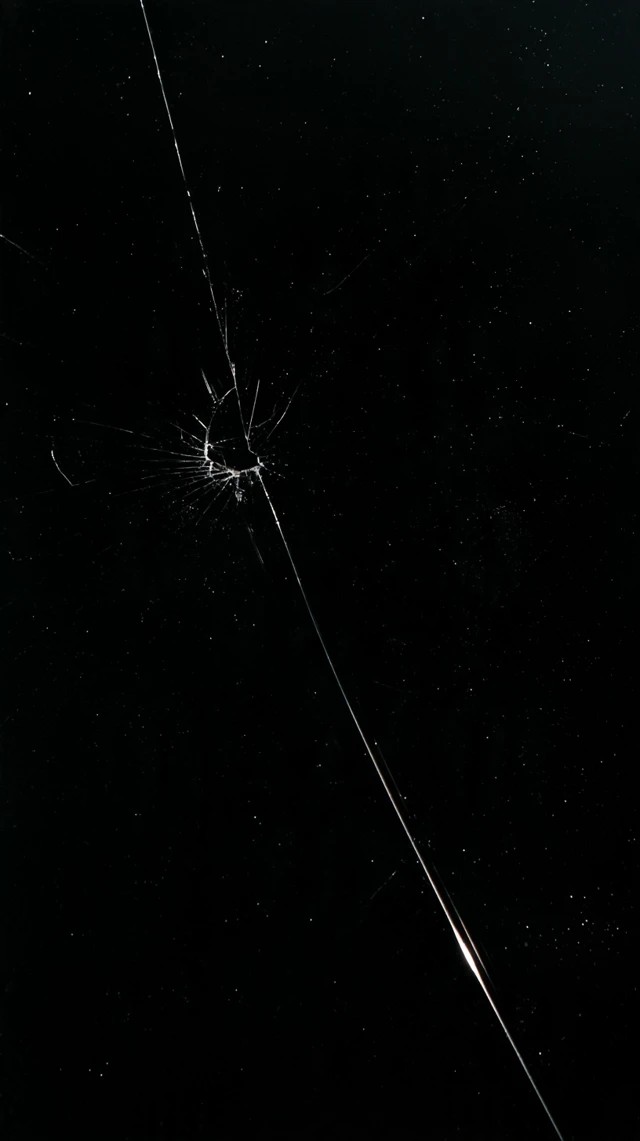 Tiny crack spreading from one point on black glass surface